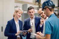 Mehrere Personen stehen zusammen und beraten sich und stehen für die Zielgruppe Kommunen | LEW Green Data Center